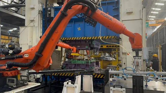 Robotic press production environment from supplied company presentation; site ownership, project attribution and visible-person identity unconfirmed
